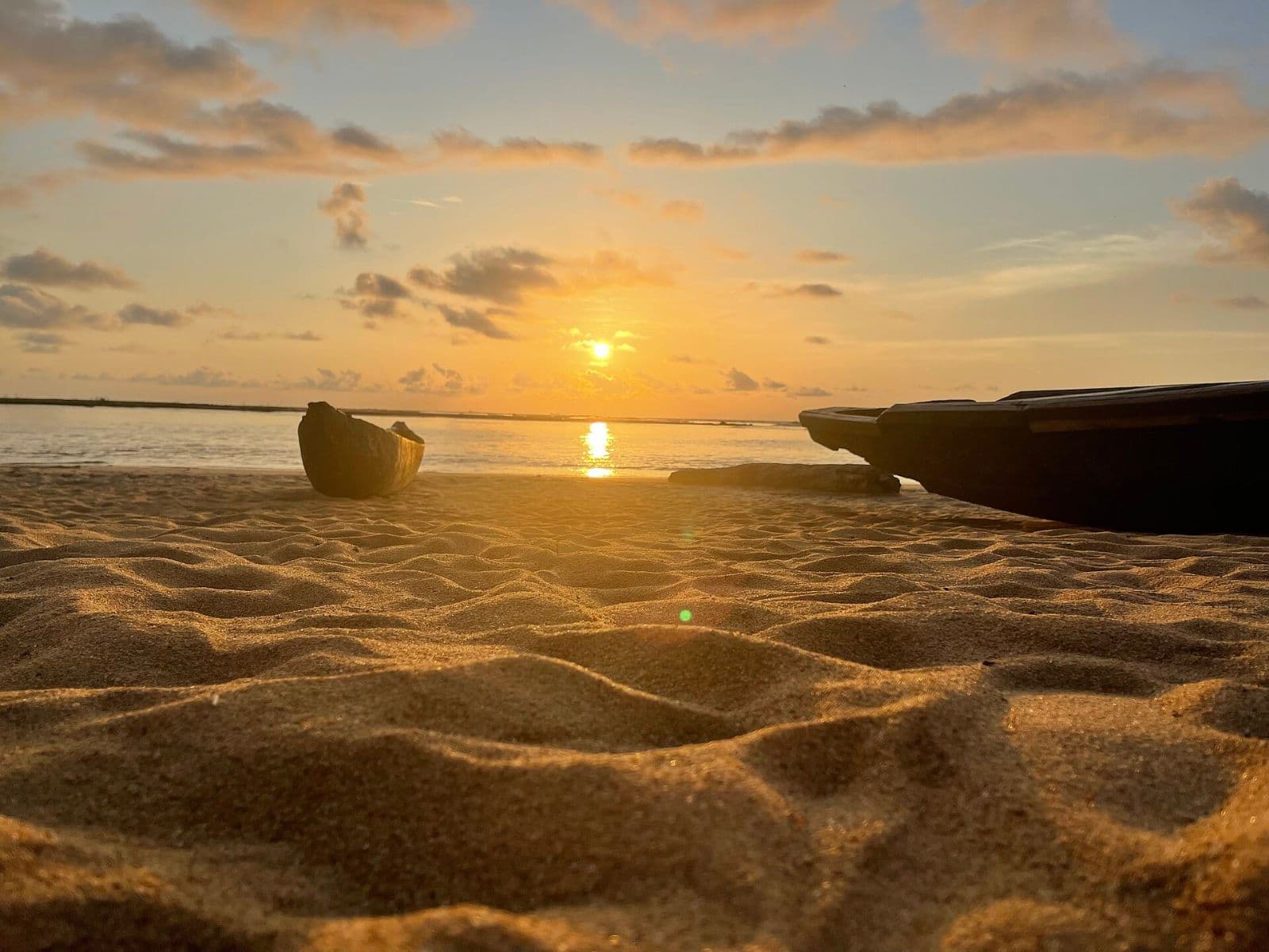 Deux pirogues de pêche échouées sur le sable de Kribi au coucher du soleil